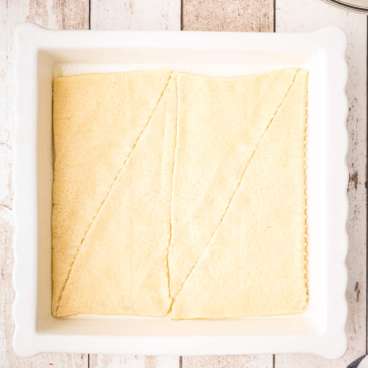 A layer of crescent roll dough in a baking dish.