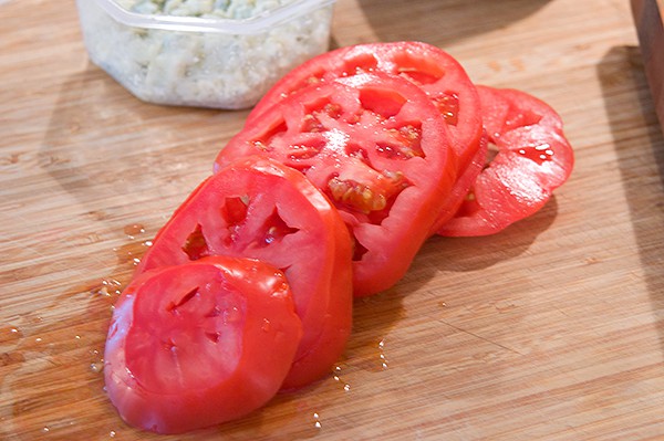 Sliced ripe tomatoes on a cutting board.