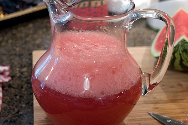 Finished watermelon cherry limeade in a glass pitcher.