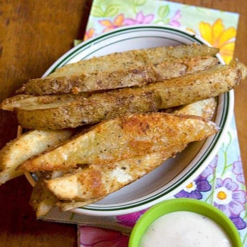 Parmesan Garlic Baked Potato Wedges from @NevrEnoughThyme https://www.lanascooking.com/parmesan-garlic-baked-potato-wedges