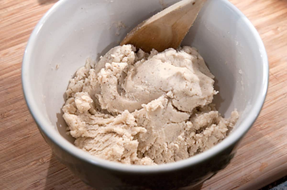 Stiff corn dodger dough in a bowl with a wooden spoon.