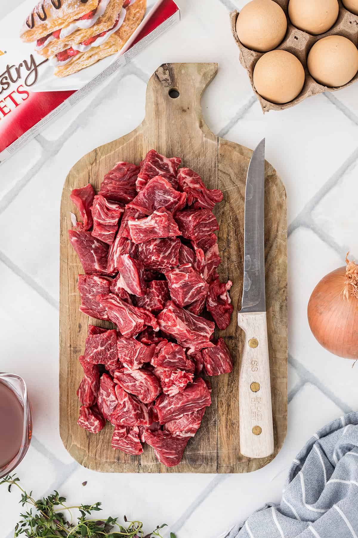 Cubes of beef on a wooden board.