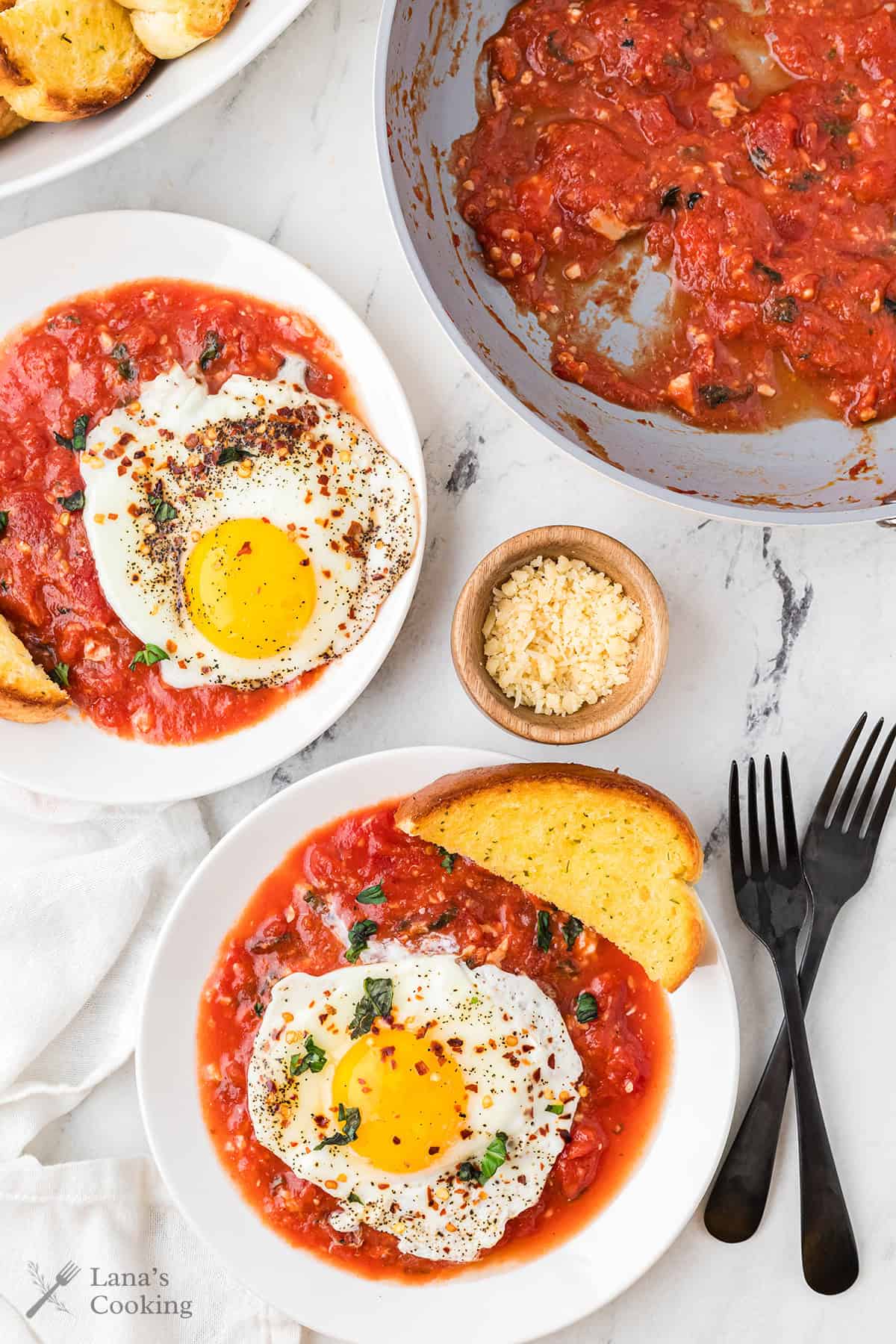 Individual servings of eggs in purgatory on white plate.