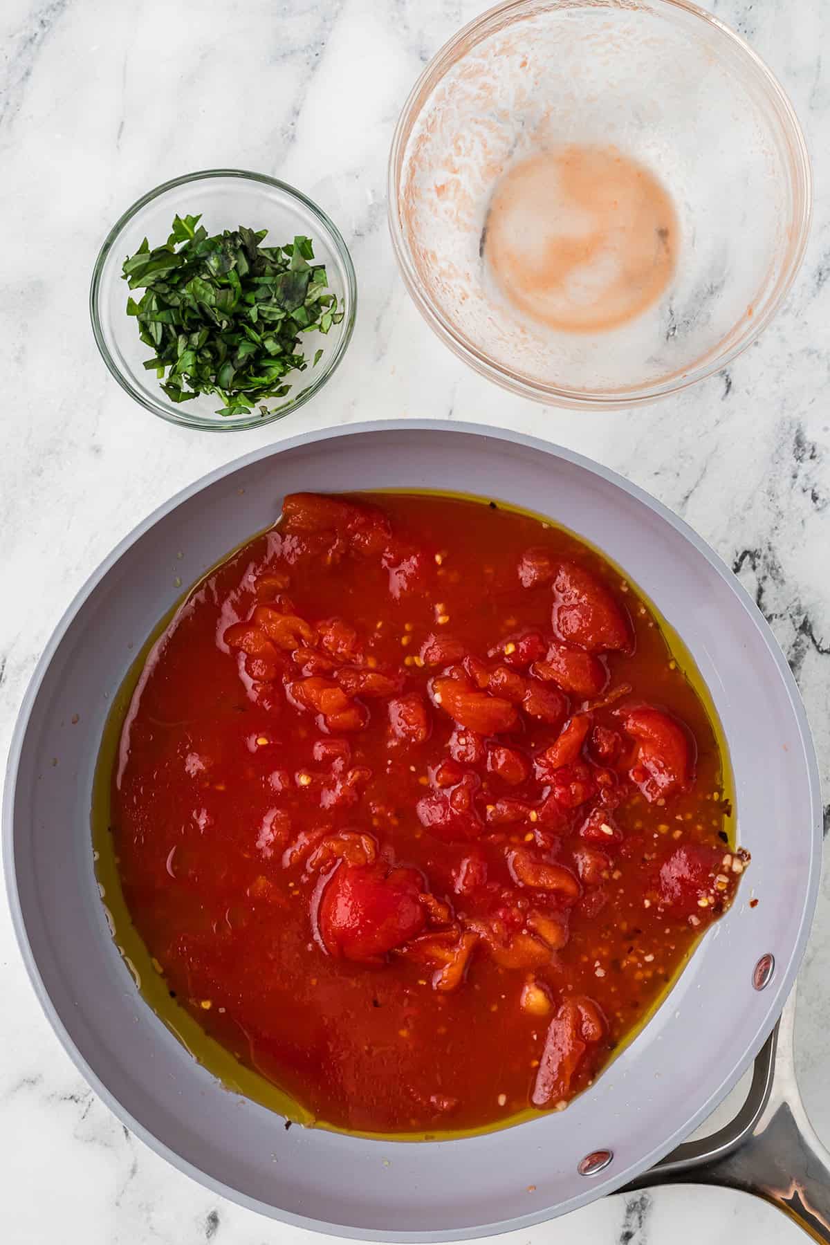Canned tomatoes added to the skillet.