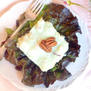 A serving of Lime Congealed Salad on a red lettuce leaf.