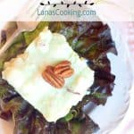 A serving of Lime Congealed Salad on a red lettuce leaf. Text overlay for pinning.