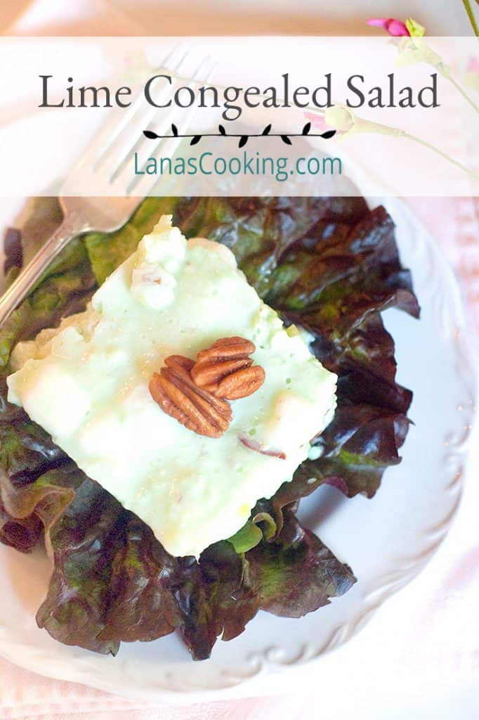 A serving of Lime Congealed Salad on a red lettuce leaf. Text overlay for pinning.