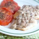 Sausage Gravy and Biscuits with Tomatoes - A hearty country breakfast of sausage gravy served over biscuits with baked, herbed tomato slices on the side. https://www.lanascooking.com/sausage-gravy-and-biscuits-with-tomatoes