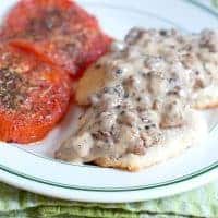 Sausage Gravy and Biscuits with Tomatoes - A hearty country breakfast of sausage gravy served over biscuits with baked, herbed tomato slices on the side. https://www.lanascooking.com/sausage-gravy-and-biscuits-with-tomatoes