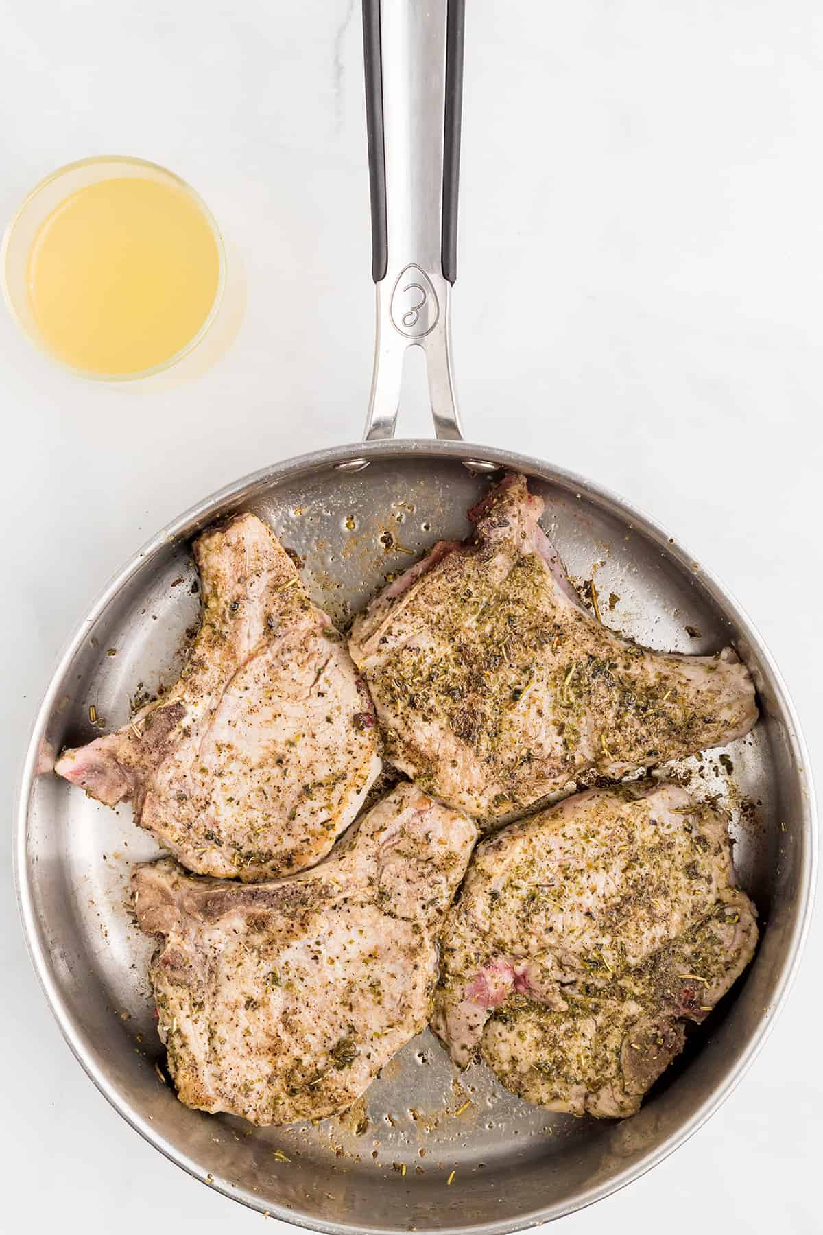 Pork chops after browning on first side.