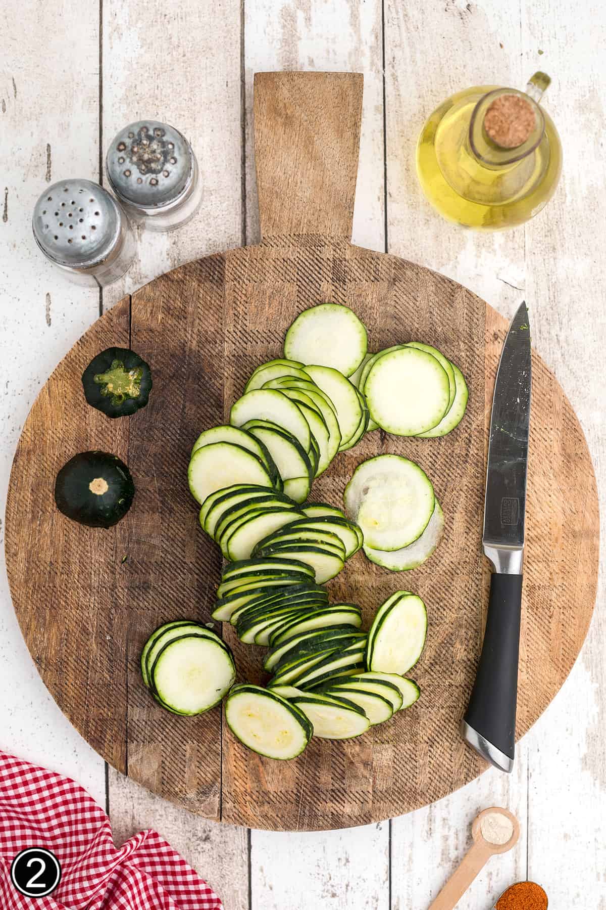 Thinly sliced zucchini on a cutting board.