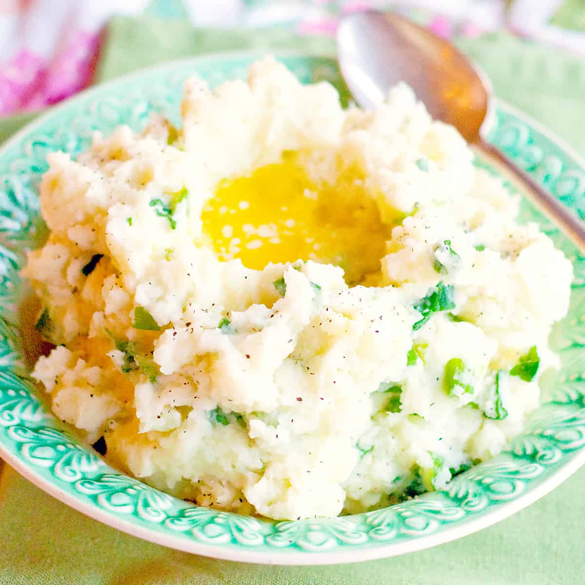 Traditional Irish Champ in a serving bowl with a well of melted butter in the center.