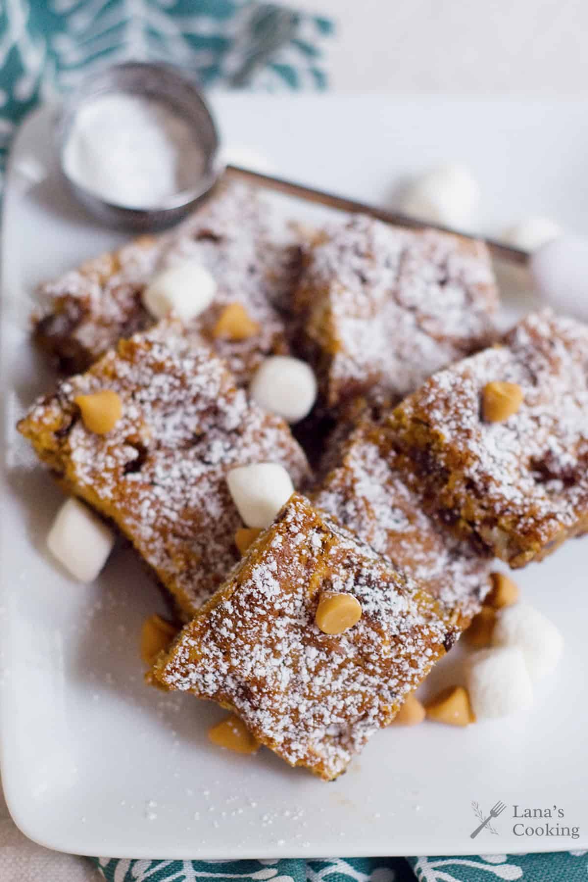 Butterscotch brownies arranged on a white plate.