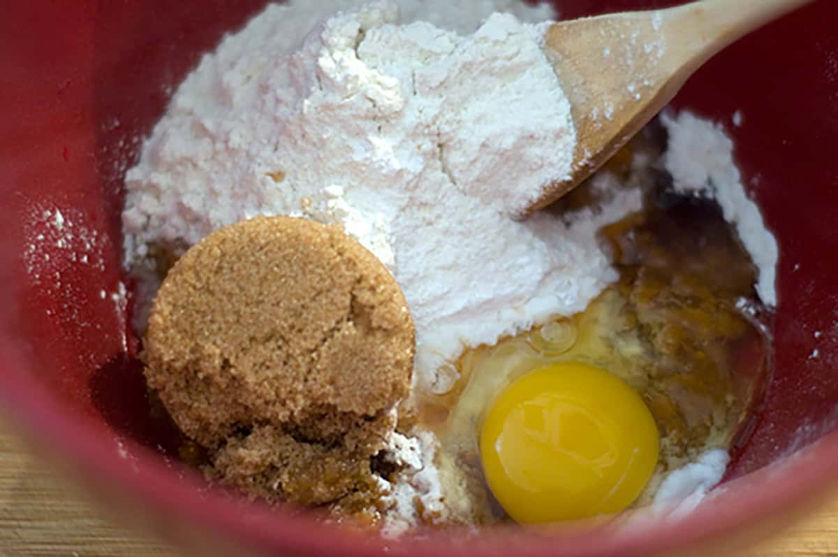 Mixing flour, eggs, and sugar in a bowl.