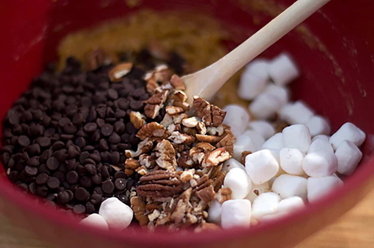 Adding nuts and marshmallows to the batter.