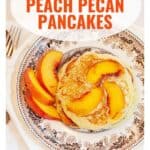 A plate of pancakes topped with peach slices and pecans, with extra peach slices on the side.