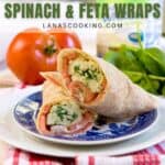 A plate with two spinach and feta wraps sits on a red and white towel, with fresh spinach, a tomato, and a carton in the background. Text overlay advertises the wraps.