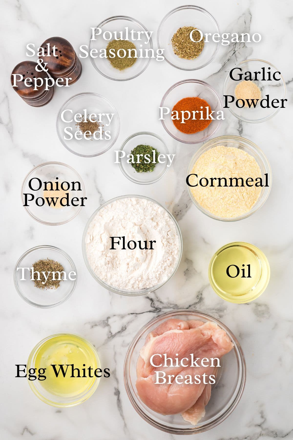 Ingredients for chicken tenders on a marble background.