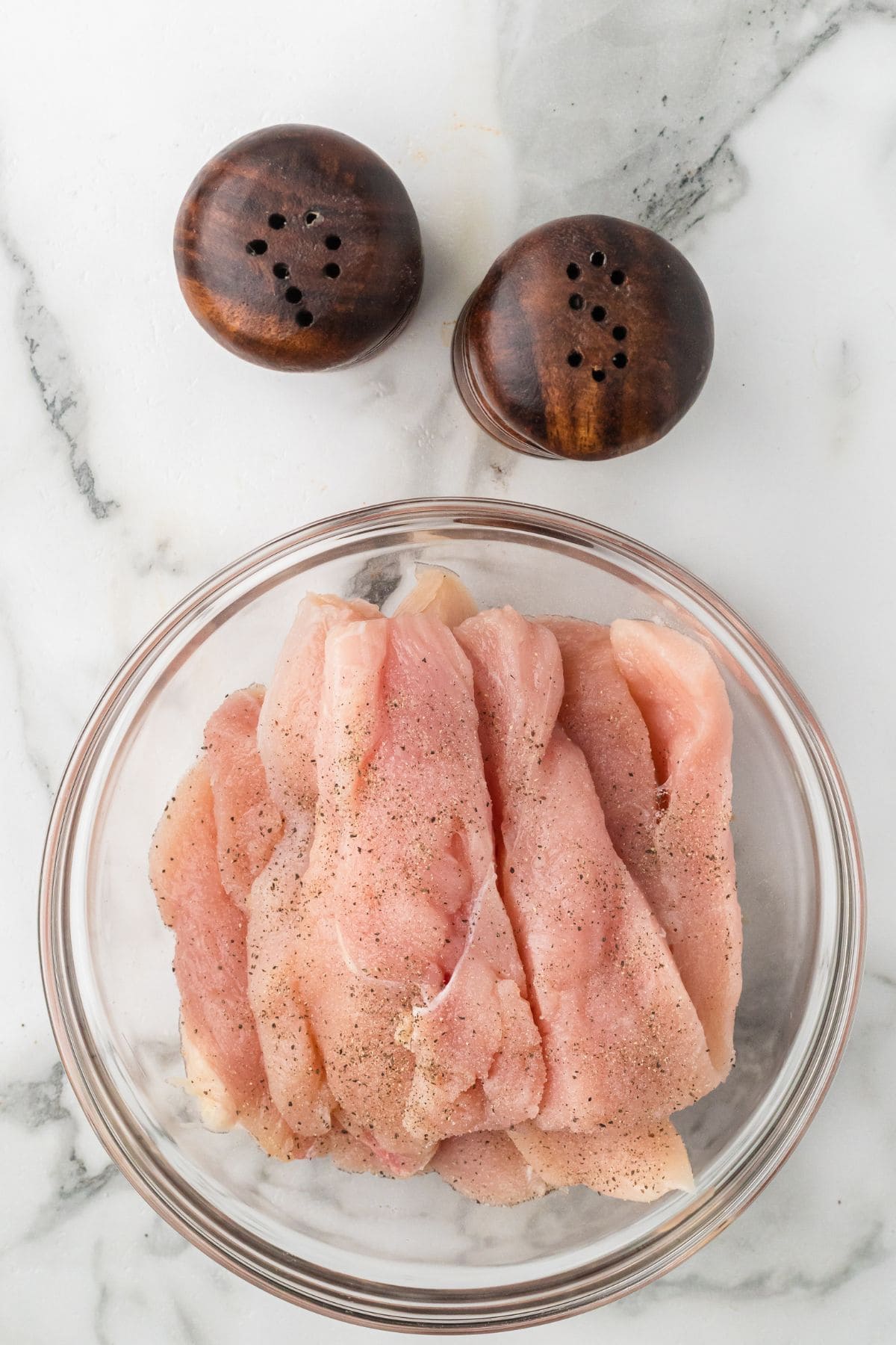 Chicken strips seasoned with salt and pepper.