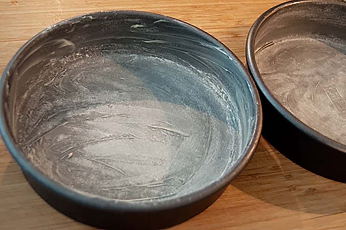 Two cake pans prepped with butter and flour.