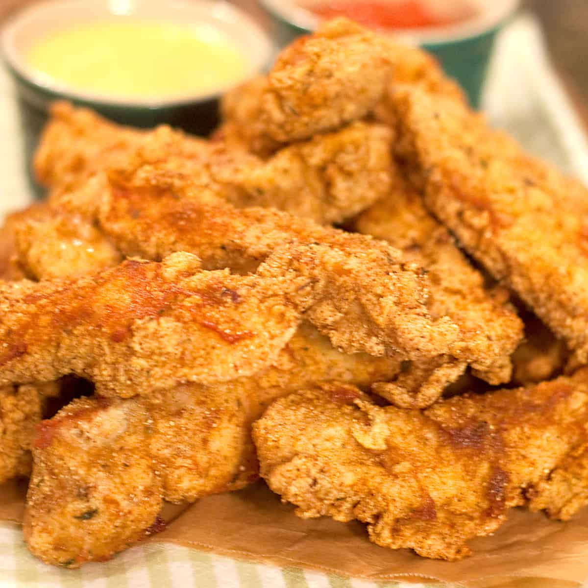 Fried chicken fingers piled on a kitchen towel.