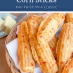 Basket of golden-brown pimiento cheese corn sticks on a white napkin.