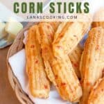 Basket of pimiento cheese corn sticks on a white napkin, with butter on the side.