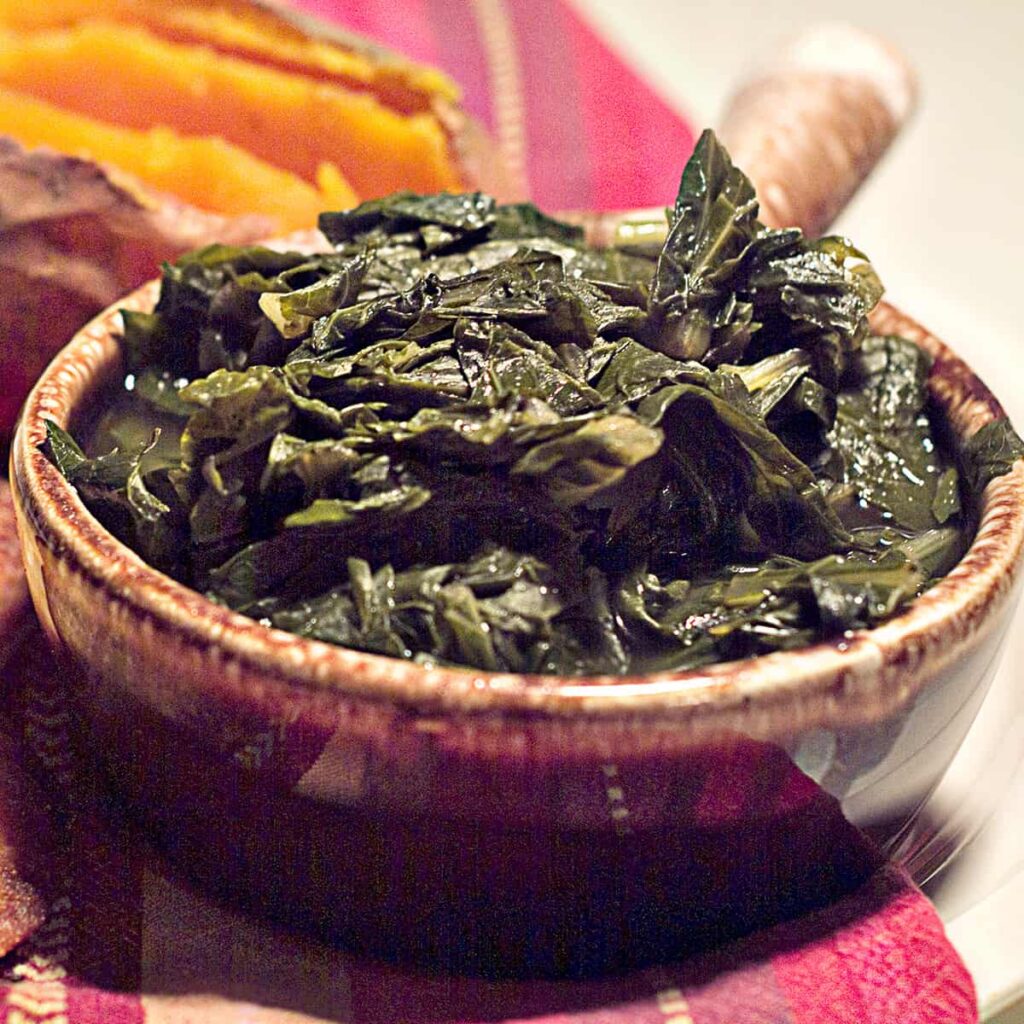 A serving of cooked turnip greens in a brown bowl.