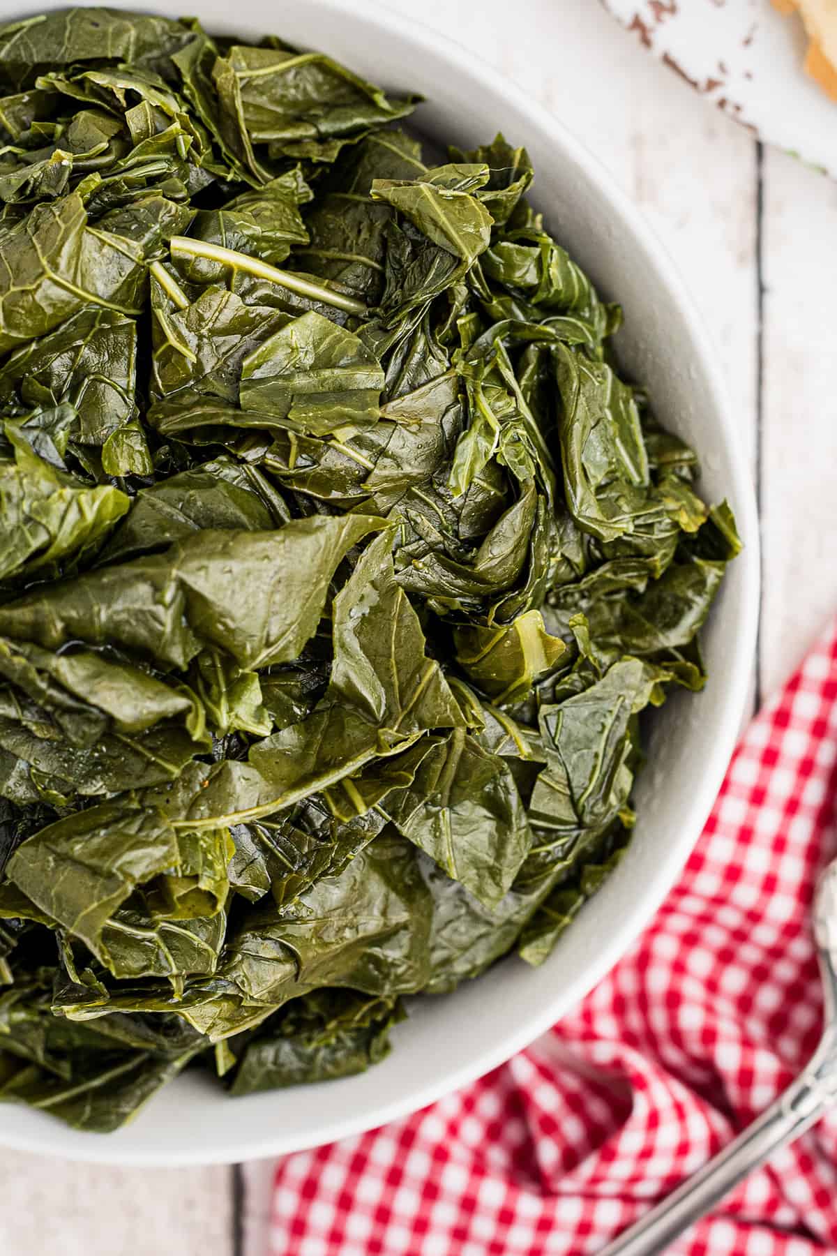 Cooked turnip greens in a white serving bowl.