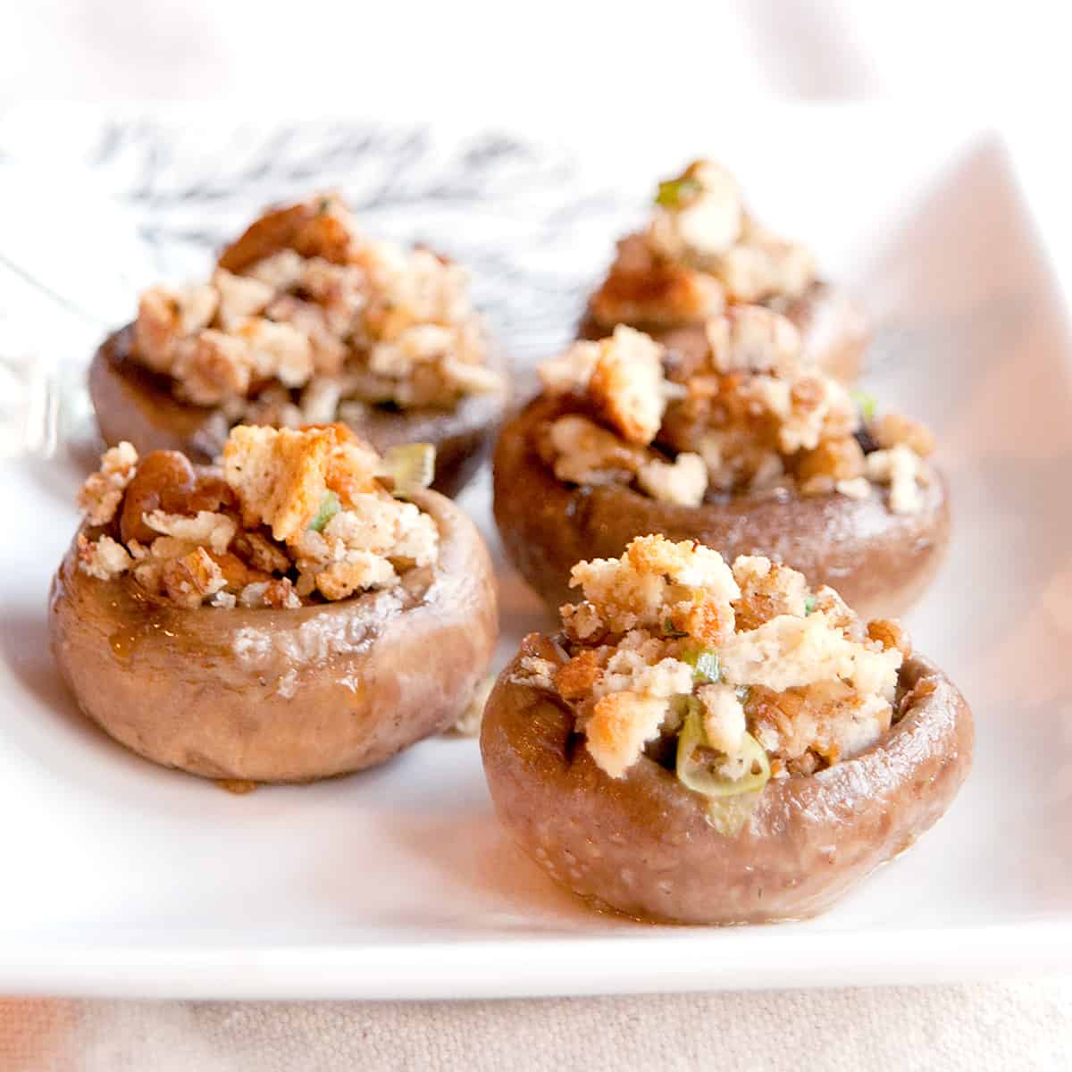 Pecan stuffed mushroom on a white serving plate.