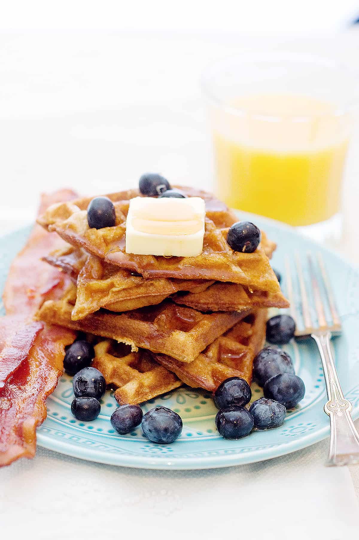A stack of waffles garnished with fresh blueberries.