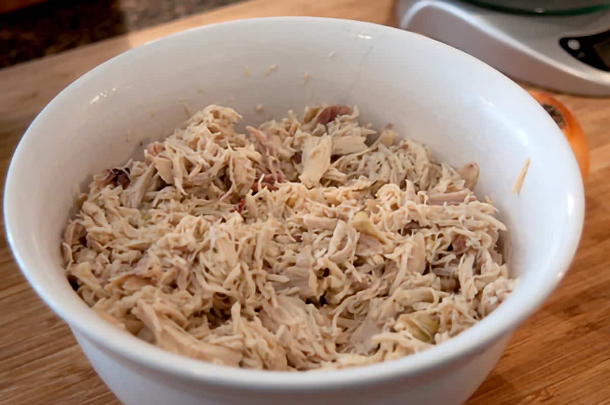 Shredded chicken in a mixing bowl.
