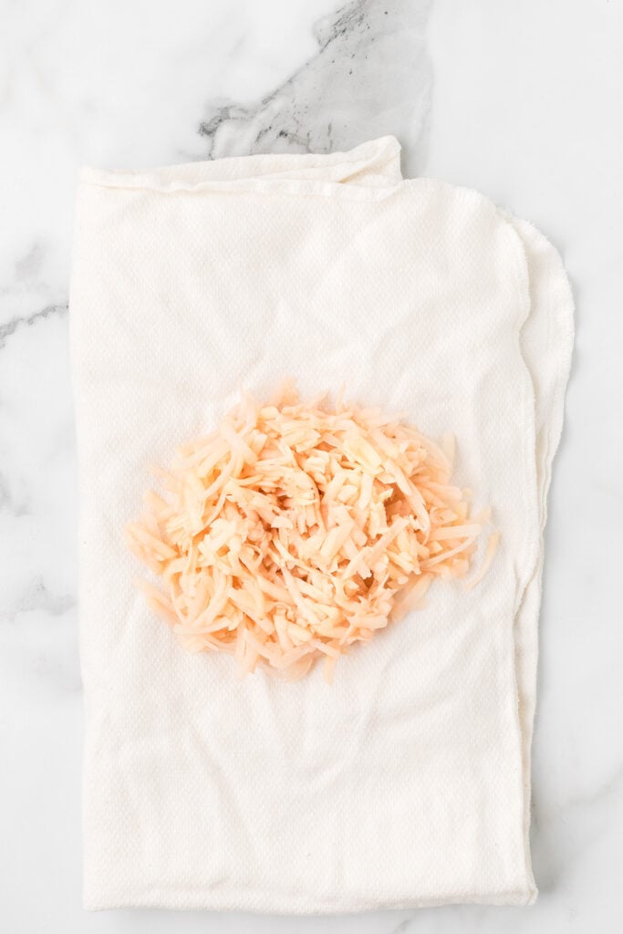 Grated raw potatoes in a towel.