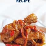 Two pieces of paprika chicken with onions and red peppers on a white plate; text reads Paprika Chicken Recipe.