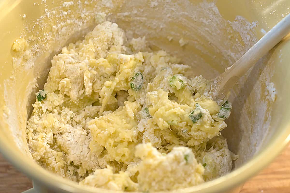 Potato mixture with flour added in a mixing bowl.