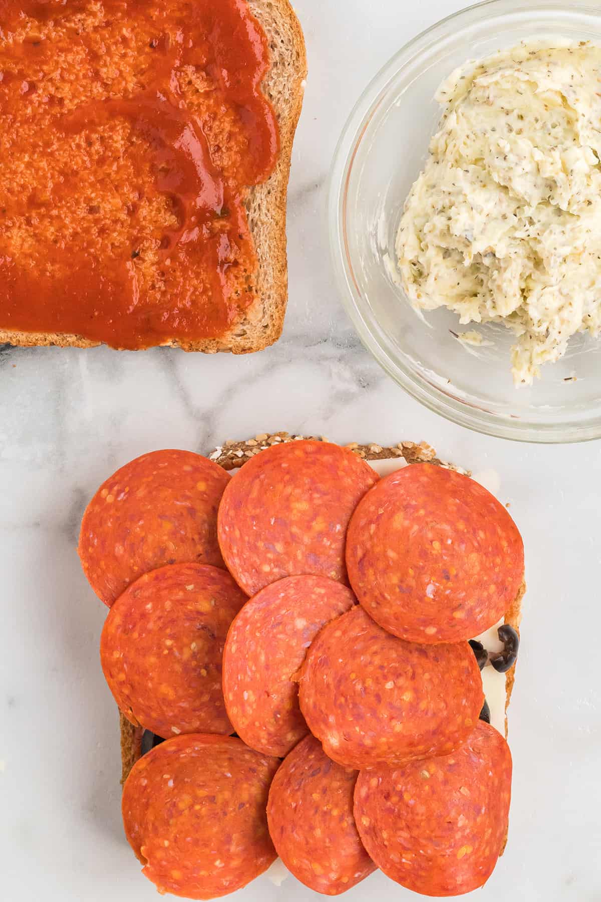 Slices of pepperoni added to the assembled sandwiches.