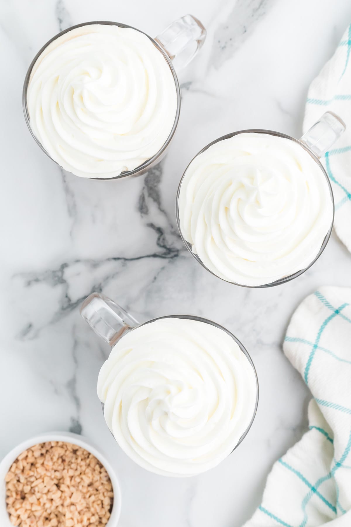 Garnishing cups with whipped cream.