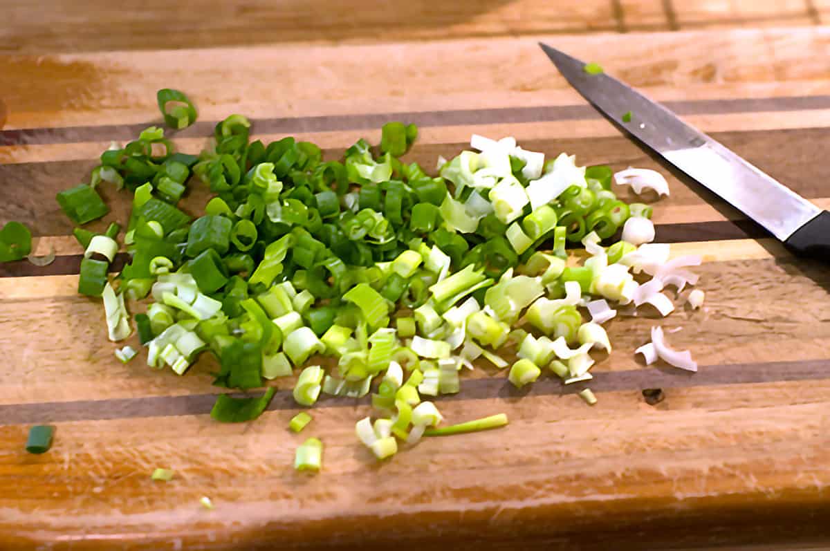 Chopped green onions on a cutting board.