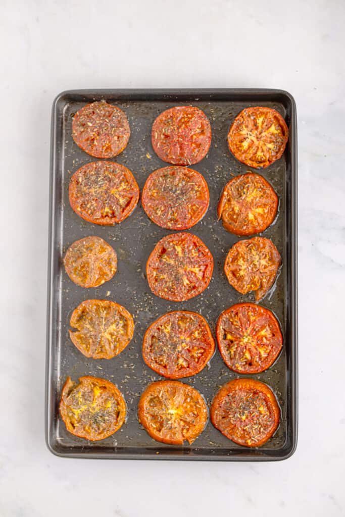 Cooked tomato slices on a baking tray.