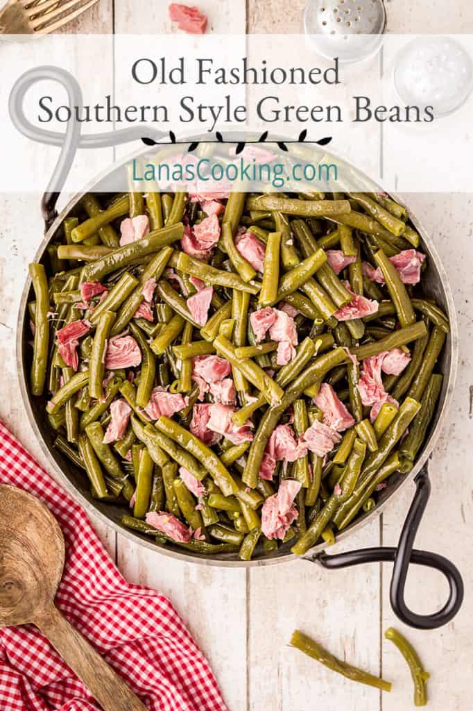 Old Fashioned Southern Style Green Beans with ham hocks in a serving dish on a tabletop. Text overlay for pinning.