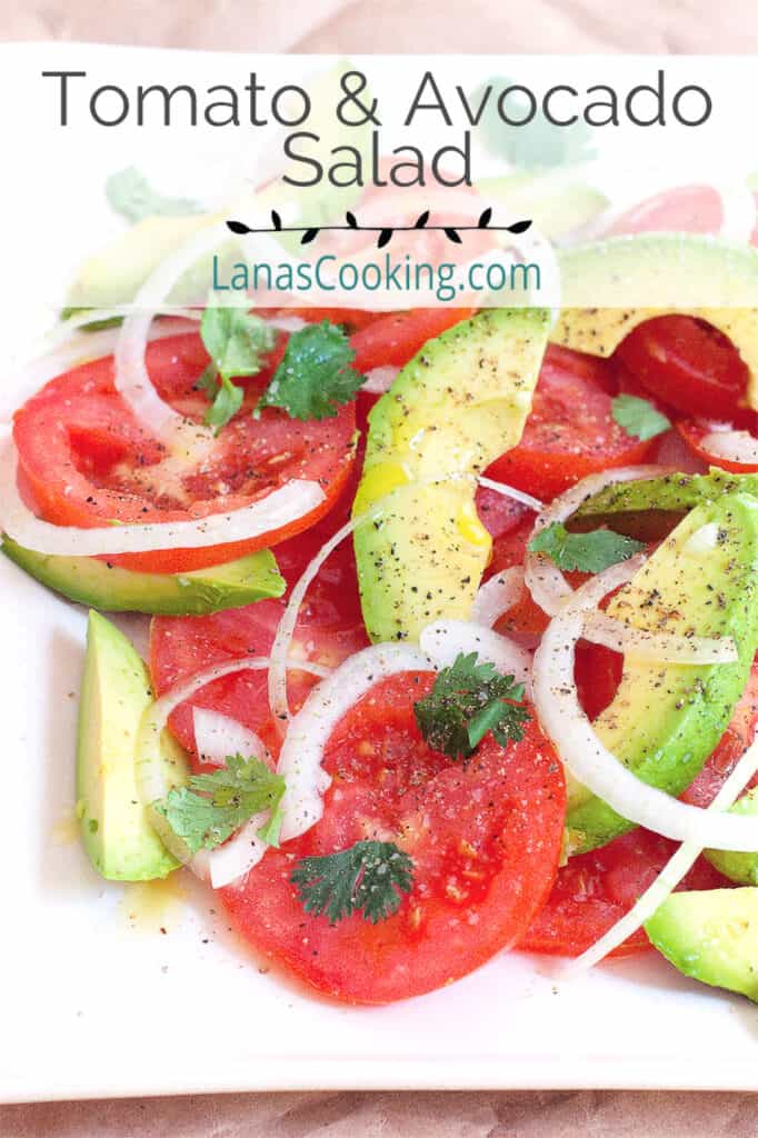 Tomato and avocado salad on a large white serving plate.