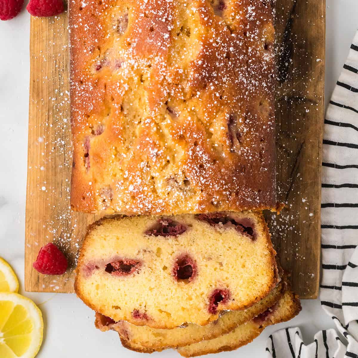 A loaf of lemon raspberry bread on a wooden board.