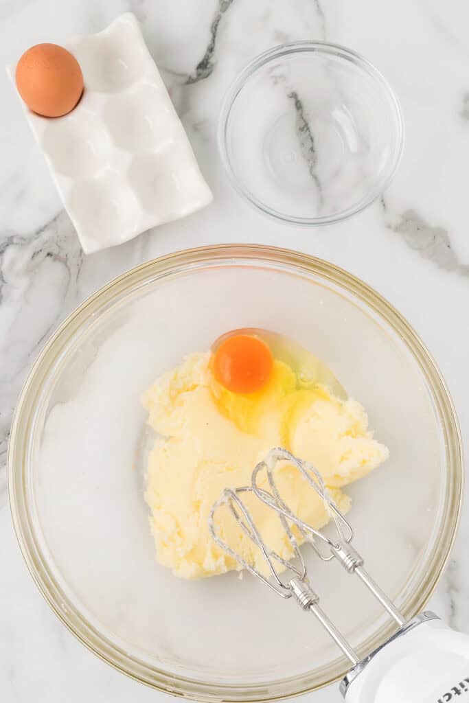 Eggs being added to the creamed butter and sugar.