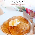 Finished pancakes topped with yogurt and syrup on a white serving plate.