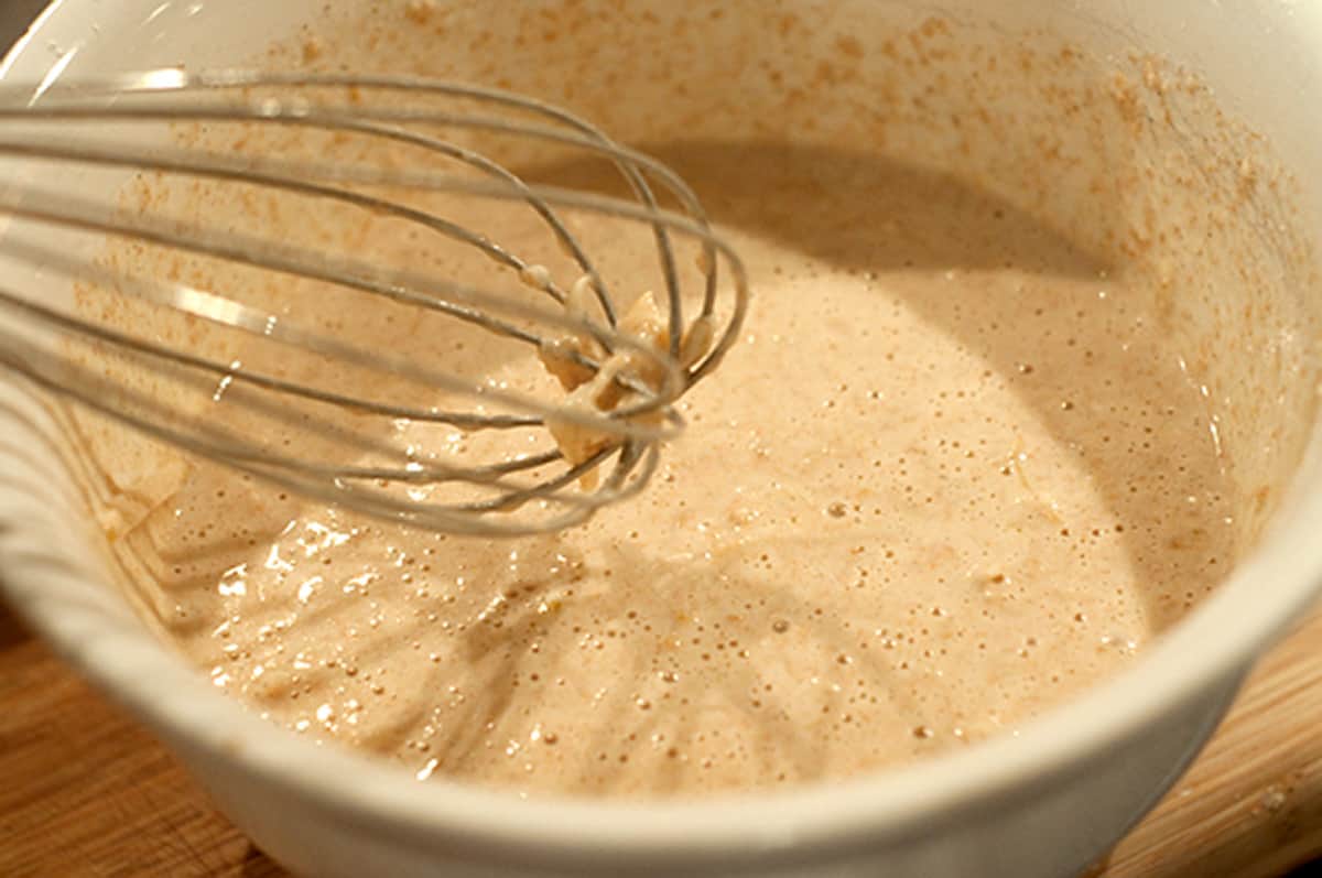 Wet and dry ingredients combined in a mixing bowl.