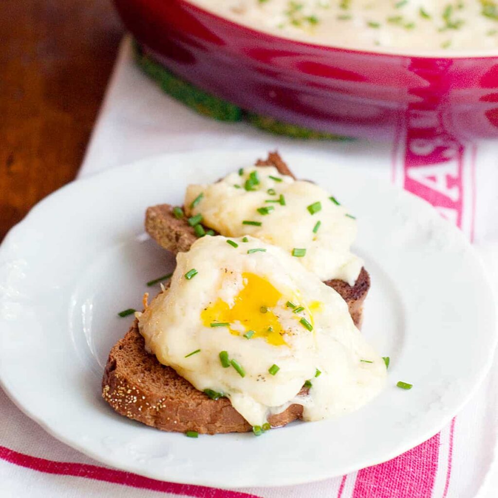 A serving of alpine eggs over toasted pumpernickel bread.