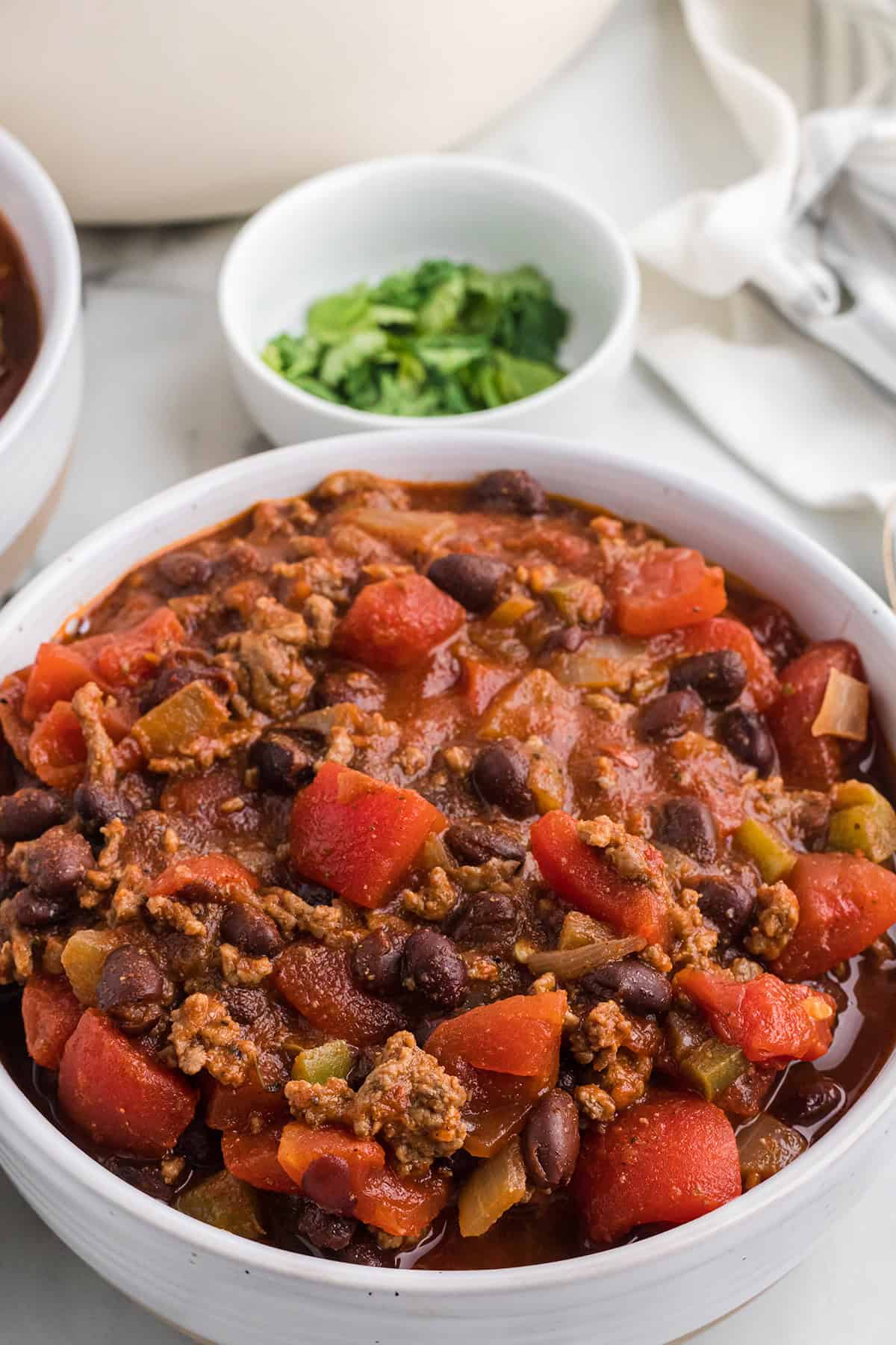 Finished chili in a white serving bowl.