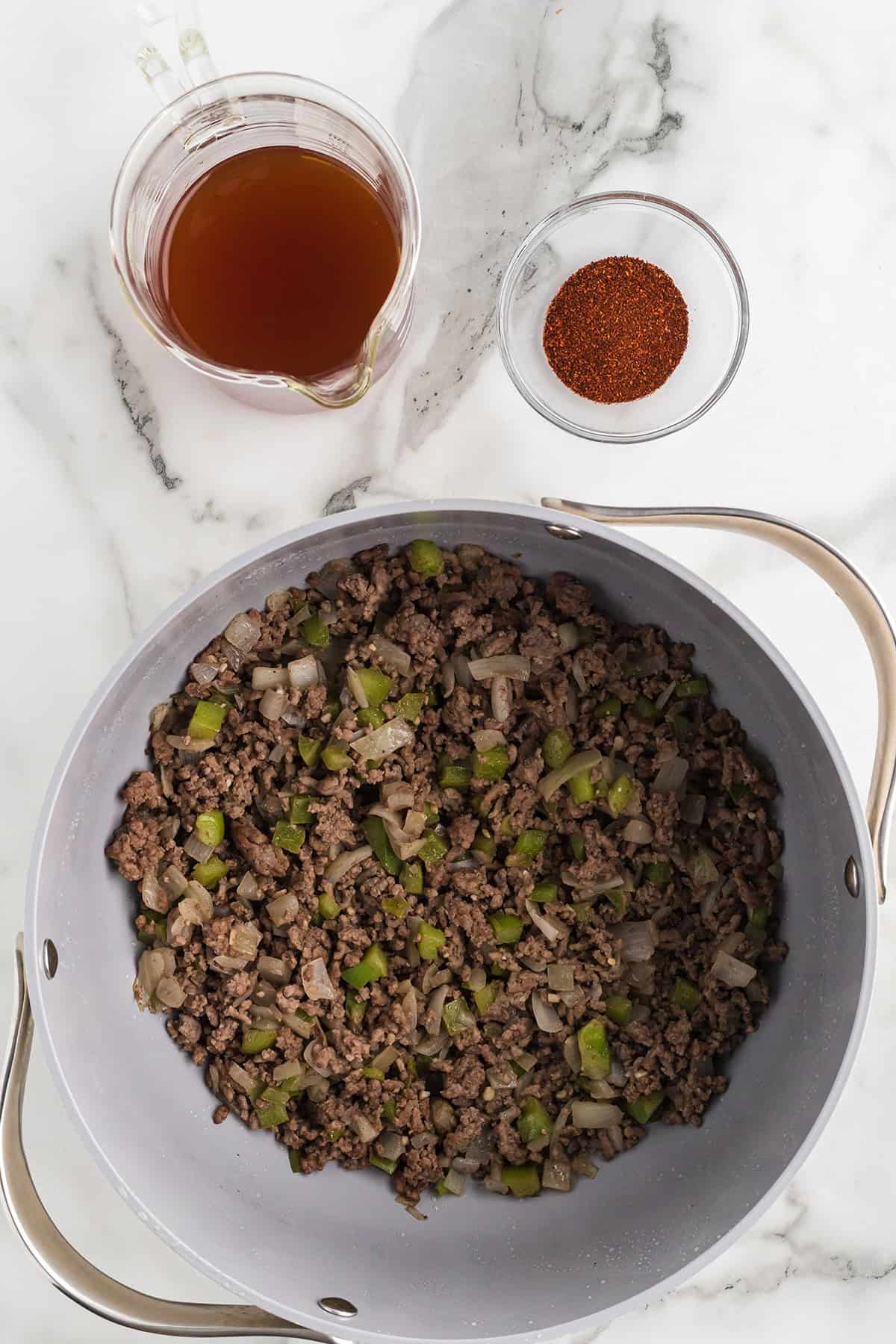 Browned beef and vegetables in a pot.