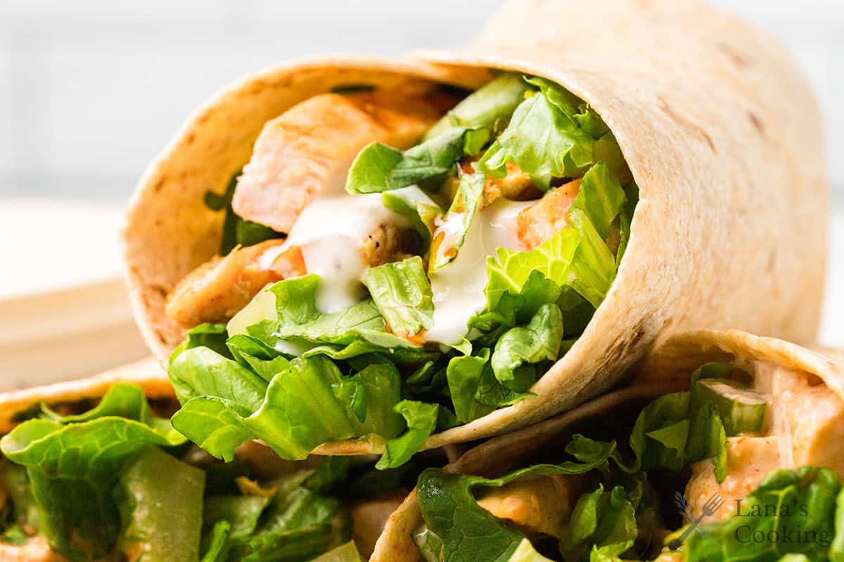 A buffalo chicken wrap showing the chicken and vegetables on the interior.