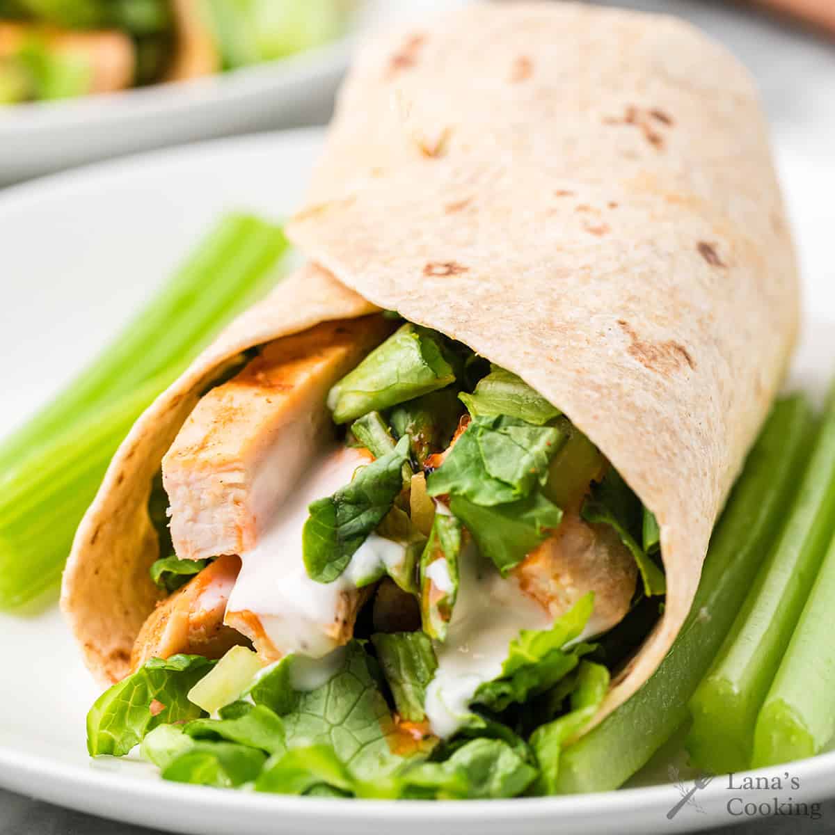 A buffalo chicken wrap showing the chicken and vegetables on the interior.